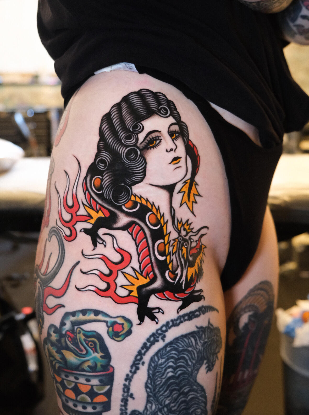 vintage woman with dragon and flames, traditional color tattoo done in Amsterdam