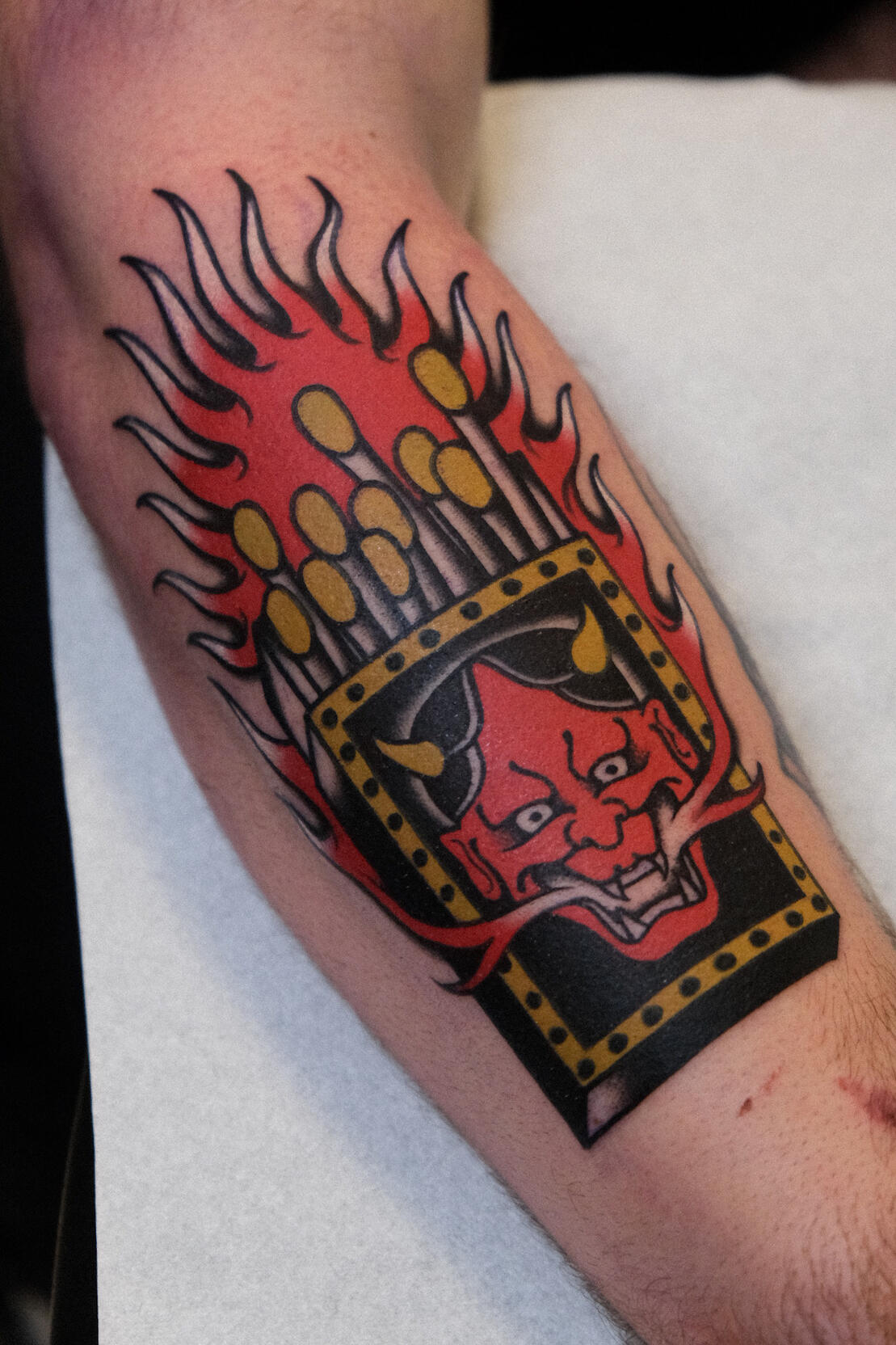 Matchbox with Hannya mask and flames, traditional tattoo with Japanese influences.